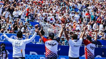 Kim Woojin and Brady Ellison celebrating with fans in stands.